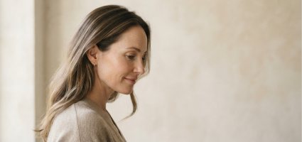 A person in profile against a warm plaster wall.